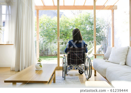 Young woman sitting on wheelchair 61239444