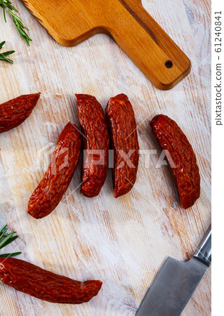 Sliced half-smoked sausages susena on wooden table. Traditional Chezh meat products Sliced half-smoked sausages susena on wooden table. Traditional Chezh meat products 61240841
