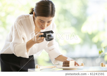 Woman taking a picture of sweets 61241591