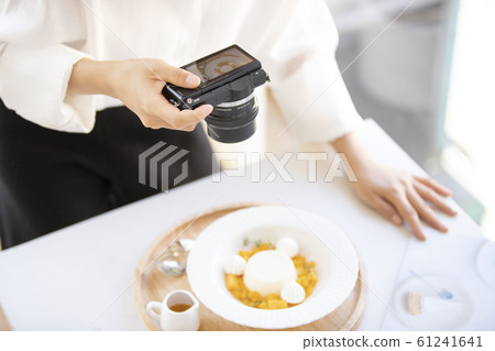 Woman taking a picture of sweets 61241641