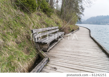 Empty old wooden bench at a park by sea 61242251