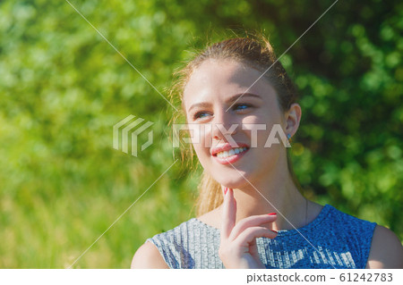 Happy beautiful girl in the sun smiling looking at 61242783
