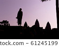 Silhouette of Angkor Wat and girl traveler with photo camera on the sunrise. Angkor Wat - Hindu 61245199