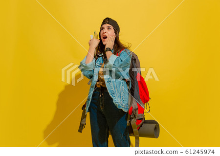Portrait of a cheerful young caucasian tourist girl isolated on yellow background 61245974