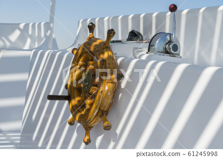 Wooden ship's steering wheel. The yacht's steering wheel. The yacht's steering wheel sails on the sea 61245998