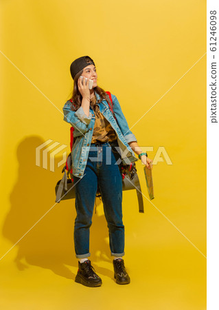 Portrait of a cheerful young caucasian tourist girl isolated on yellow background 61246098