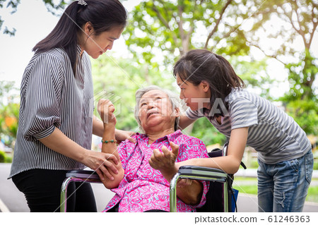 Sick senior grandmother in wheelchair with epileptic seizures in outdoor,elderly patient convulsions suffering from illness with epilepsy during seizure attack,asian daughter,granddaughter crying,fami 61246363