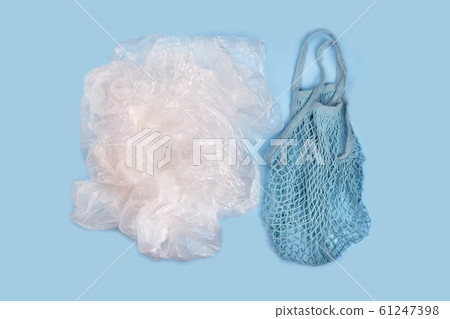 String reusable bags and a pile of plastic bags 61247398