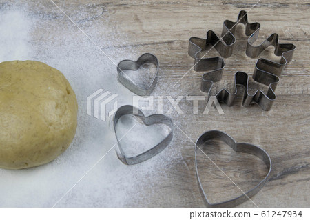 Preparation of ginger biscuits. A metal form in the form of gingerbread man for cutting figured cookies. 61247934