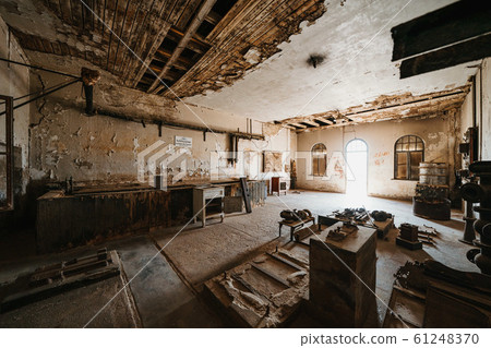 abandoned old workstation in ruined partially collapsed building 61248370