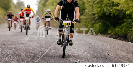 group cyclists riders riding on gravel road group cyclists riders riding on gravel road 61249985