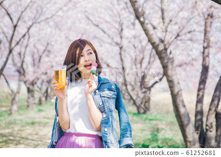 Woman with Hanami dumpling and beer 61252681