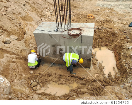 Casted pile cap at the construction site. It is part of the building foundation system. Protruded rebar is for the next stage of work. 61254735