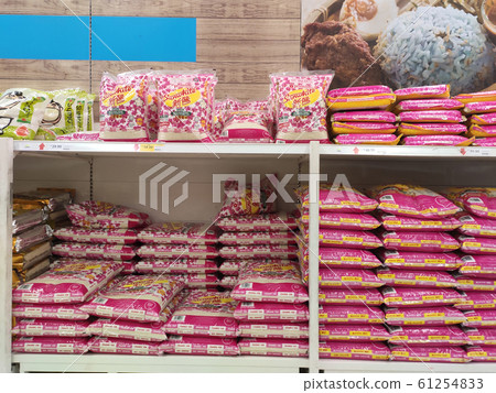 The rice in the plastic packaging is stacked and displayed on the rack inside the supermarket for sale. Variety of type and price. Sorted by brands.  61254833