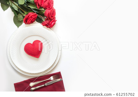 Table setting with red heart and bouquet of red roses. View from above. Valentine day. Table setting with red heart and bouquet of red roses. View from above. Valentine day. 61255702