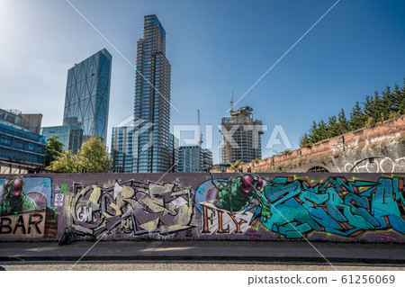 Graffiti covered wall with high rise city Graffiti covered wall with high rise city 61256069