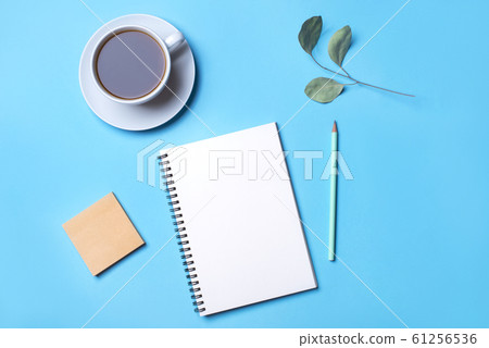 Blue background with notepad, pencil and cup of coffee. Blue background with notepad, pencil and cup of coffee. 61256536
