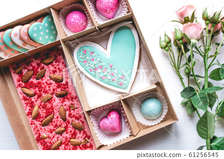 Gift set with hand made sweets in a box on a white table. Gift set with hand made sweets in a box on a white table. 61256545