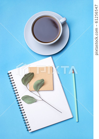 Blue background with notepad, pencil and cup of coffee. Blue background with notepad, pencil and cup of coffee. 61256547