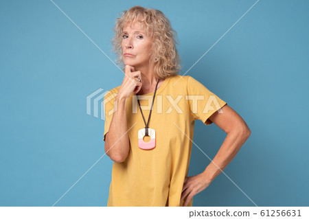 Senior blond woman listening interlocutor, thinking, waiting the results 61256631