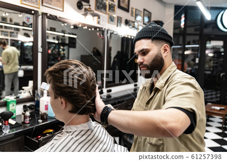 The client receives a haircut and hair styling in a beauty salon.  61257398