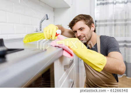 Young Man in Yellow Gloves Using Cleanser 61266348