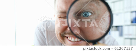 Smiling businessman hold magnifying glass 61267137