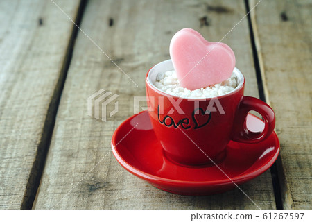 Pink heart shape on red coffee cup with wood table background ,vintage love concept. 61267597