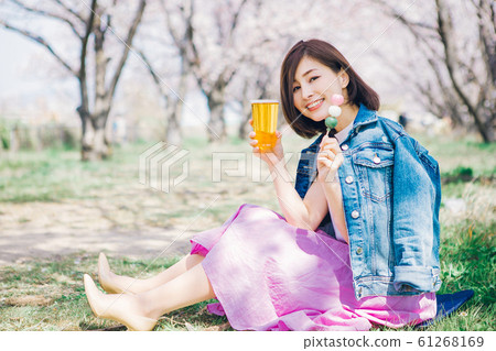 Woman with cherry blossom viewing dumpling and beer 61268169