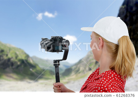 woman videographer using steady cam, 61268376