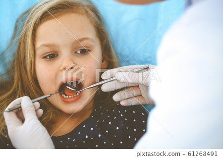 Little baby girl sitting at dental chair with open mouth during oral check up while doctor. Visiting dentist office. Medicine concept. Toned photo 61268491