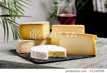 Different french cheeses with a glass of wine 61268996