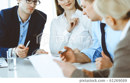 Group of business people discussing questions at meeting in modern office. Managers at negotiation or brainstorm. Teamwork, partnership and business concept 61269089