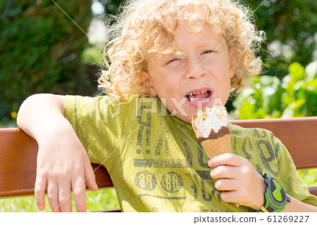 little blond boy eating an ice outside little blond boy eating an ice outside 61269227