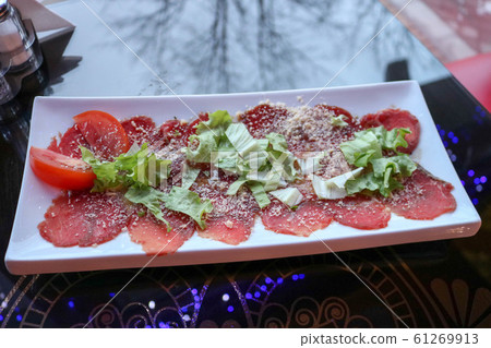 Carpaccio of red beef and pork with tomatoes Carpaccio of red beef and pork with tomatoes 61269913