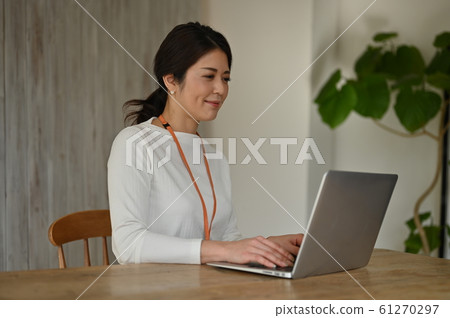 A woman working toward a personal computer 61270297
