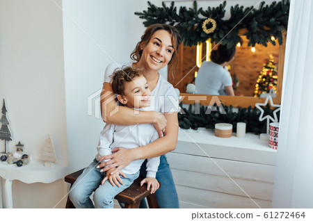 beautiful mother hugs her son on the couch 61272464
