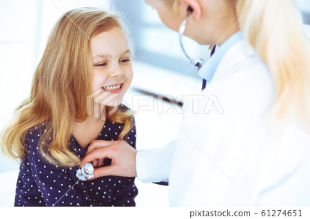 Doctor examining a child patient by stethoscope. Cute baby girl at physician appointment. Medicine concept. Toned photo 61274651