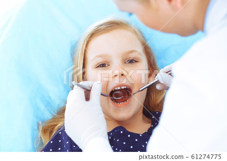 Little baby girl sitting at dental chair with open mouth during oral check up while doctor. Visiting dentist office. Medicine concept. Toned photo 61274775