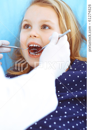 Little baby girl sitting at dental chair with open mouth during oral check up while doctor. Visiting dentist office. Medicine concept. Toned photo 61274826