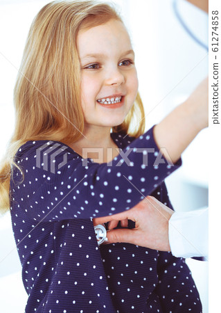 Doctor examining a child patient by stethoscope. Cute baby girl at physician appointment. Medicine concept. Toned photo Doctor examining a child patient by stethoscope. Cute baby girl at physician appointment. Medicine concept. Toned photo 61274858