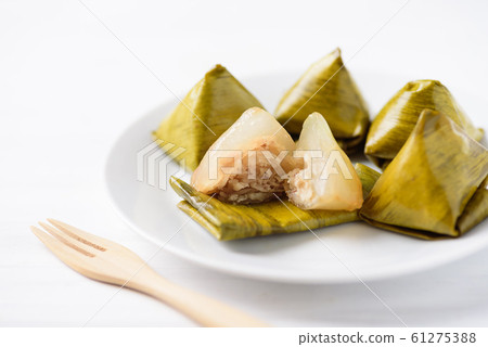 Thai dessert (Khanom Tian), sweet stuffed dough pyramid wrapped by banana leaf Thai dessert (Khanom Tian), sweet stuffed dough pyramid wrapped by banana leaf 61275388
