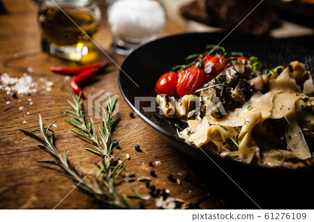 Black Angus Pasta served in a black bowl in restaurant 61276109