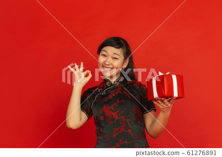 Happy Chinese new year. Asian young girls's portrait isolated on red background Happy Chinese new year. Asian young girls's portrait isolated on red background 61276891