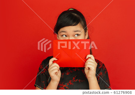 Happy Chinese new year. Asian young girls's portrait isolated on red background Happy Chinese new year. Asian young girls's portrait isolated on red background 61276908
