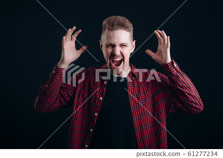 Brown-haired Youngster With Hands Raised Showing Anger Emotions Brown-haired Youngster With Hands Raised Showing Anger Emotions 61277234