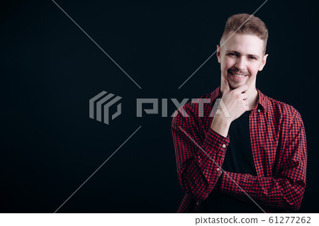 Young Handsome Guy Smiling and Rubbing Chin Young Handsome Guy Smiling and Rubbing Chin 61277262