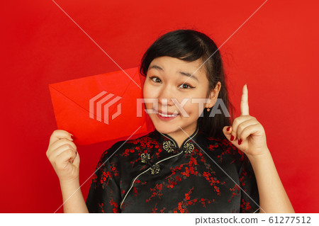 Happy Chinese new year. Asian young girls's portrait isolated on red background 61277512