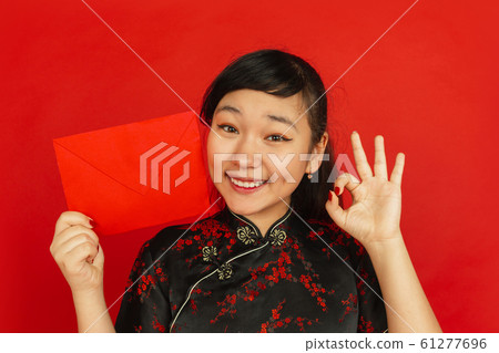 Happy Chinese new year. Asian young girls's portrait isolated on red background Happy Chinese new year. Asian young girls's portrait isolated on red background 61277696