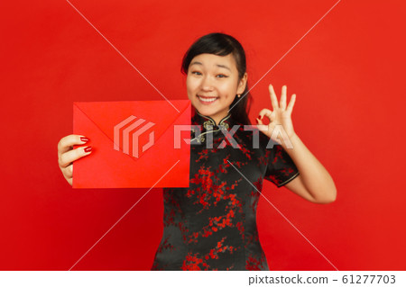 Happy Chinese new year. Asian young girls's portrait isolated on red background 61277703